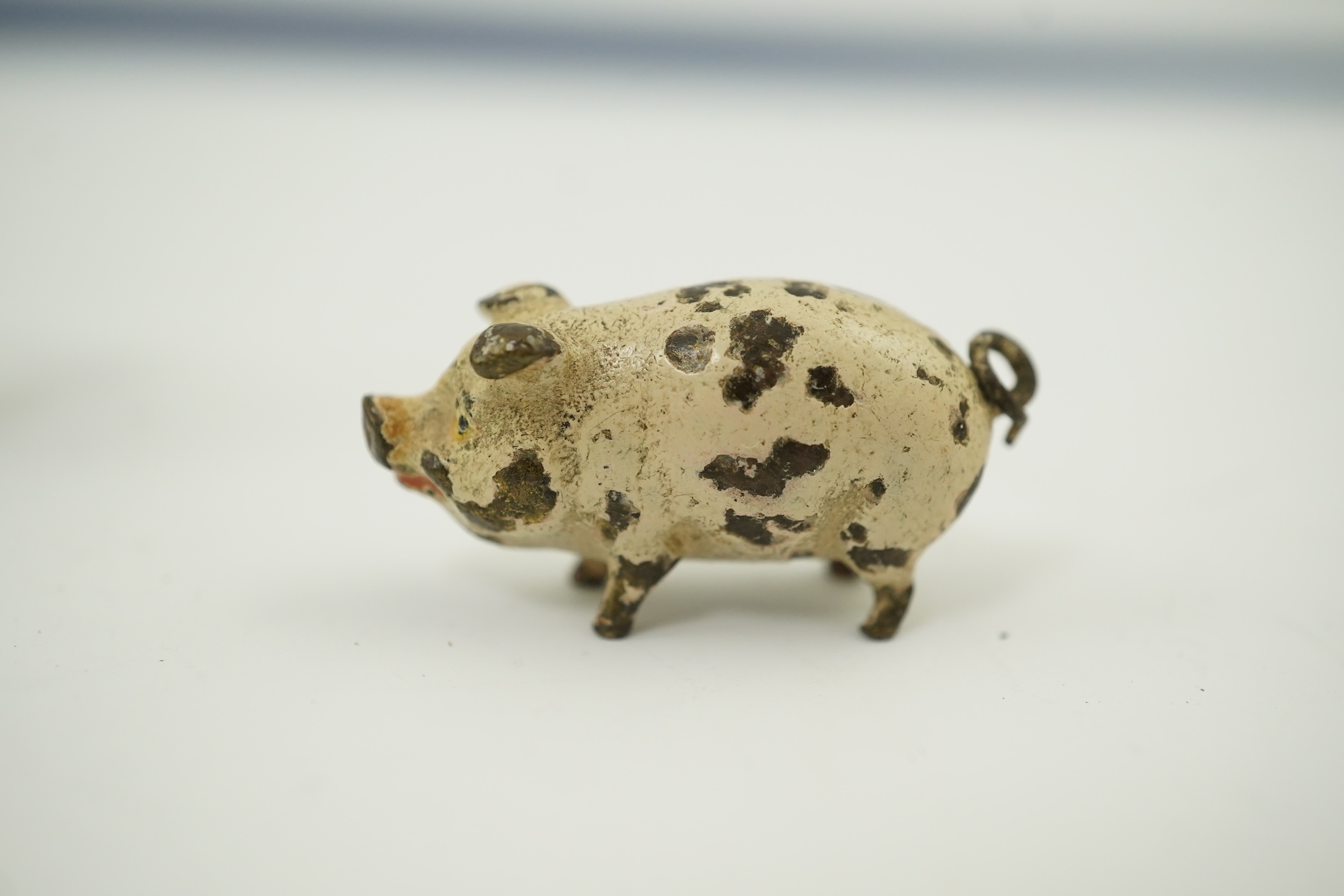 Four novelty miniature cold painted bronzes; black boy with cradle, black baby, cat and pig and a similar articulated arm skeleton stickpin,7cm long. Condition - some chipping to paint